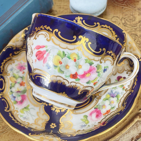 An antique Coalport cup and saucer, handpainted flowers, cobalt blue